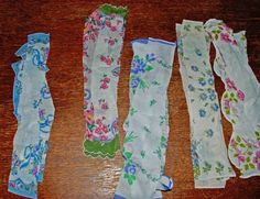 five pairs of cloth garters laid out on top of a wooden table next to each other