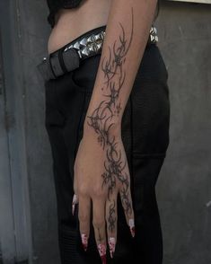 a woman's arm with tattoos on it and her hand holding the wrist tattoo