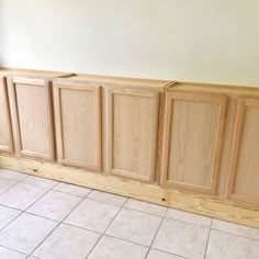 an unfinished kitchen cabinet with white tile flooring