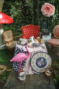 an assortment of furniture and decorations in a garden with pink flamingos on the table