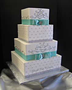 a three tiered wedding cake with blue bows