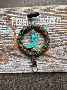 a keychain with a turquoise letter on it