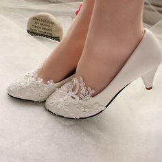 a woman's white high heeled shoes with lace