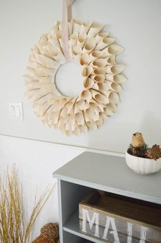 a wreath hanging on the wall above a book shelf