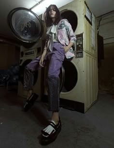 a woman standing in front of a washer with her legs up on the floor