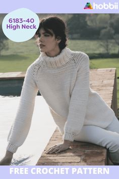 a woman sitting on the edge of a pool wearing a white sweater and pants with her legs crossed