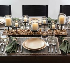 a table set with place settings and candles