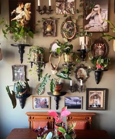 a dining room table with many plants and pictures on the wall