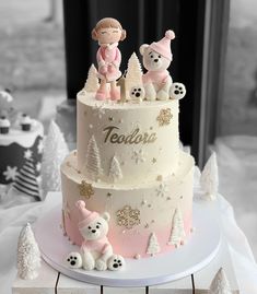 a three tiered cake with teddy bears and snowflakes on the bottom layer