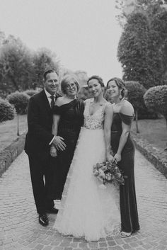 a group of people standing next to each other on a brick walkway with trees in the background