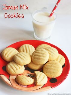 there are cookies on the plate with milk in the glass next to it and a red straw