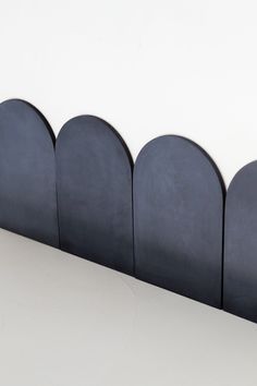 a row of black circles sitting on top of a white counter next to a wall