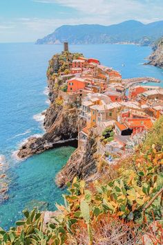 an aerial view of a small village on the edge of a cliff by the ocean