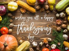 thanksgiving greeting card with corn, pumpkins and other vegetables on a wooden background that says wishing you all a happy thanksgiving day