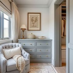 a room with a chair and dresser in it