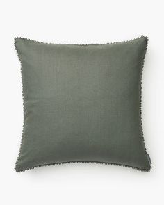 a green pillow with scalloped edges on a white background, the front is made from linen