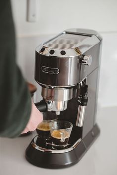 a coffee maker is being used to make espresso