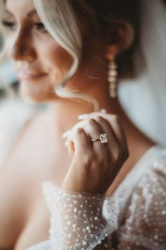 a woman wearing a wedding dress and holding her hands together