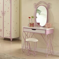 a pink dressing table with mirror and stool