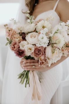 a woman holding a bouquet of flowers in her hands