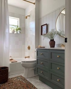 a bathroom with green cabinets and white walls