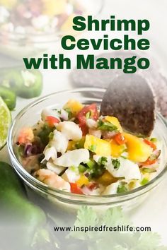 shrimp cevichche with mango in a glass bowl next to limes and cilantro