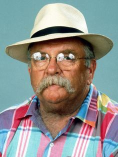 an older man wearing glasses and a hat with eyeballs in his eyes is looking at the camera