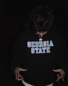 a person standing in the dark with their hands on their hips and wearing a sweatshirt that says georgia state