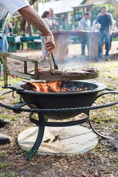 Man grilling large steaks on an outdoor fire kettle. Don't Believe Anyone, Fire Pit Cooking, Open Fire Cooking, Fire Cooking, Rocket Stoves, Sea Island, Fire Pit Backyard, Pure Michigan