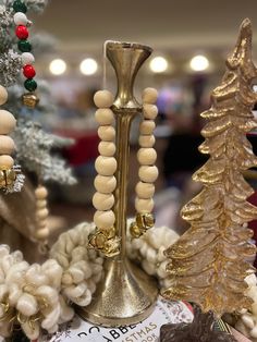 a gold candle holder is surrounded by christmas trees and other holiday decorations in the store