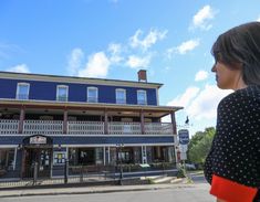 a woman standing in front of a blue building