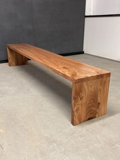 a wooden bench sitting on top of a cement floor