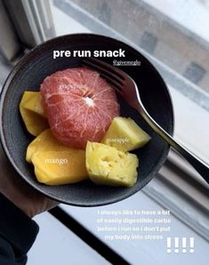 a person holding a black bowl filled with fruit and a fork in it's hand