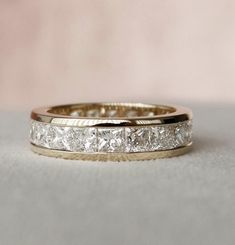 a gold wedding band with princess cut diamonds