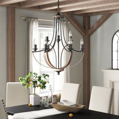 a chandelier hanging from the ceiling in a dining room with white chairs and table