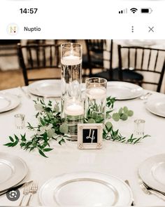 the table is set with candles and greenery for an elegant wedding reception at nuptio