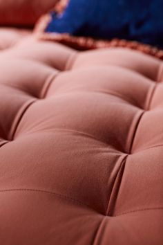 a close up view of a pink mattress with blue pillows