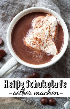 a cup of hot chocolate with marshmallows on the side and text overlay that reads, heife schokolade seler machen