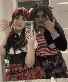 two women dressed up in costumes taking a selfie