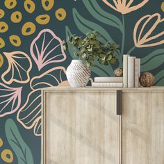 a vase with flowers and books on top of a dresser next to a wallpaper