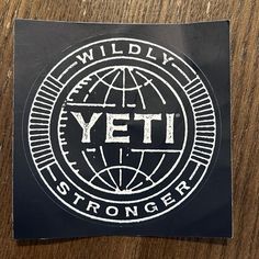 a sticker with the word yeti on it sitting on top of a wooden table