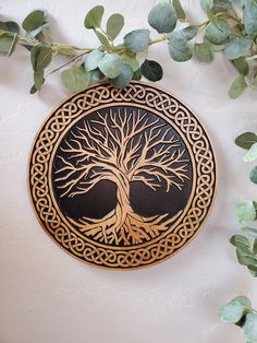 a tree is on the wall next to some green leaves and branches with an intricate design