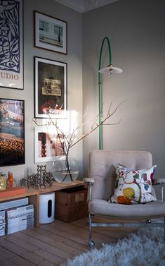 a living room filled with furniture and pictures on the wall next to a lamp shade