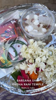 there is a tray with flowers and other items in it that are on the table