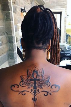 a woman with a cross tattoo on her back