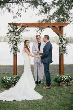 a bride and groom holding hands during their wedding ceremony