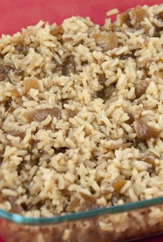 a casserole dish filled with rice and meats on a red table cloth