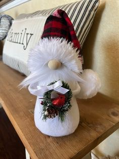 a christmas decoration sitting on top of a wooden table next to a pillow and throw pillow