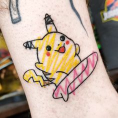 a person with a tattoo on their arm that has a drawing of a pikachu holding a surfboard