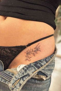 a woman's stomach with tattoos on it and flowers in the side pocket,